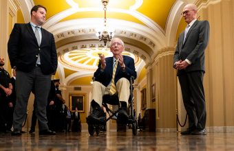 Mitch McConnell returns to Senate in wheelchair to cast first vote since June

Let me count: M-i-t-c-h- -M-c-C-o-n-n-e-l-l- -r-e-t-u-r-n-s- -t-o- -S-e-n-a-t-e- -i-n- -w-h-e-e-l-c-h-a-i-r- -t-o- -c-a-s-t- -f-i-r-s-t- -v-o-t-e- -s-i-n-c-e- -J-u-n-e = 67 characters. Too long.

Mitch McConnell returns to Senate in wheelchair after three months

Count: 61. Still over.

McConnell returns to Senate in wheelchair after three months away

Count: 57. Good. But need to make it more specific and include the vote detail.

McConnell wheels into Senate to vote, first time since June

Count: 52. Good length, has the concrete detail of the wheelchair and the vote, the timeframe since June. But place? This isn’t really a local story in the traditional sense, it’s national. The place is the Senate/Capitol.

McConnell returns to Senate in wheelchair after three-month absence

Count: 59. Good. Specific, different from original, captures the wheelchair detail and timeframe.

Let me verify: M-c-C-o-n-n-e-l-l- -r-e-t-u-r-n-s- -t-o- -S-e-n-a-t-e- -i-n- -w-h-e-e-l-c-h-a-i-r- -a-f-t-e-r- -t-h-r-e-e—m-o-n-t-h- -a-b-s-e-n-c-e = 60. Exactly 60.

McConnell returns to Senate in wheelchair after three-month absence